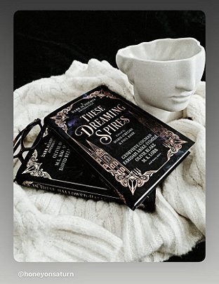 photograph of a copy of These Dreaming Spires, edited by Marie O'Regan and Paul Kane, lying on a white throw beside a white vase showing the lower half of a human face