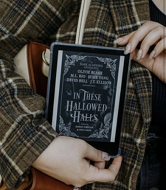 photograph of a woman in a brown plaid top holding a Kindle showing the cover of In These Hallowed Halls, edited by Marie O'Regan and Paul Kane