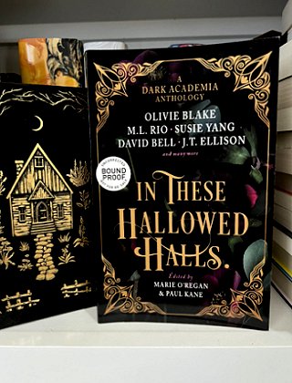A bookshelf featuring a standing copy of In These Hallowed Halls, edited by Marie O'Regan and Paul Kane, face-out on the shelf