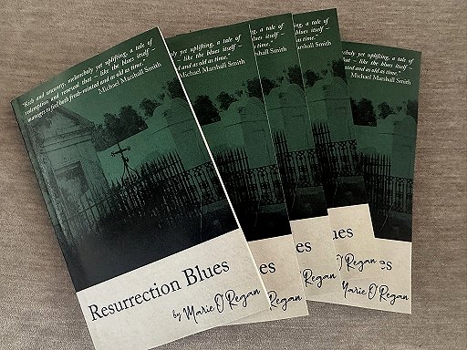 photograph showing five copies of Resurrection Blues by Marie O'Regan against a grey surface