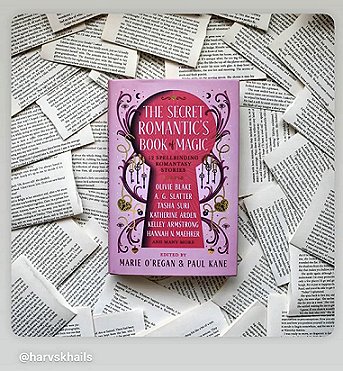 photograph of a copy of The Secret Romantic's Book of Magic, edited by Marie O'Regan and Paul Kane, lying on a bed of loose book pages