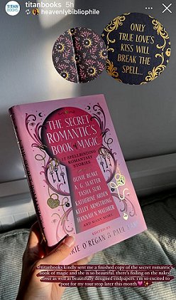 photograph of a woman's hand holding up a copy of The Secret Romantic's Book of Magic, edited by Marie O'Regan and Paul Kane. In the top right hand corner is a black circle lined with gold scrollwork. Text reads ONLY TRUE LOVE'S KISS WILL BREAK THE SPELL...