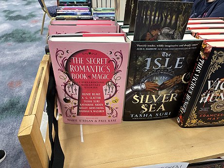photograph showing copies of The Secret Romantic's Book of Magic, edited by Marie O'Regan and Paul Kane, on a display stand at WFC2025