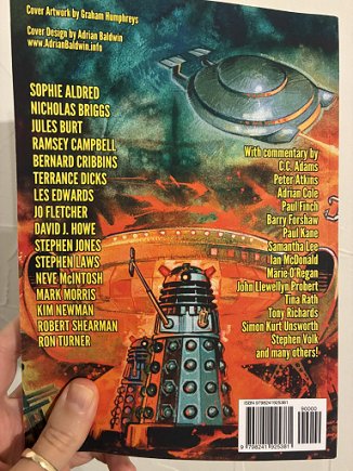 photograph showing a man's hand holding up the Phantasmagoria Daleks Special to show the back cover.